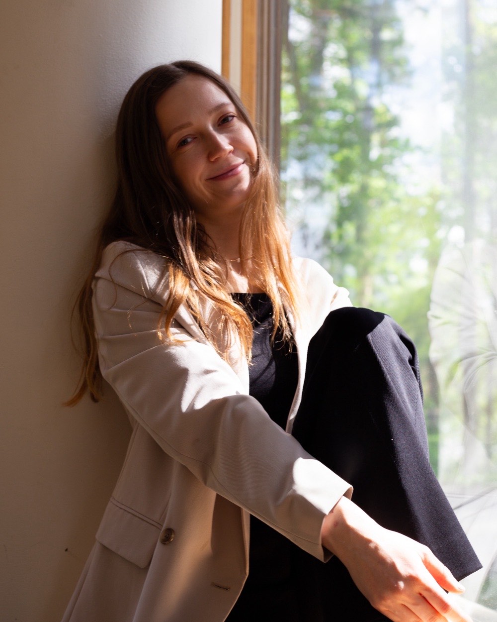 Laura Auna istuu ikkunalaudalla